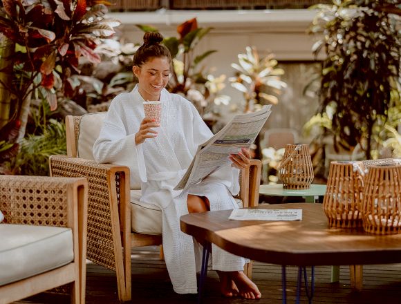 girl in spa robe enjoying coffee by pool