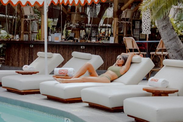 woman lounging by pool and bar